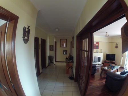 Wide angle view of hallway with the kitchen to the left and the two bedrooms at the end of the hallway